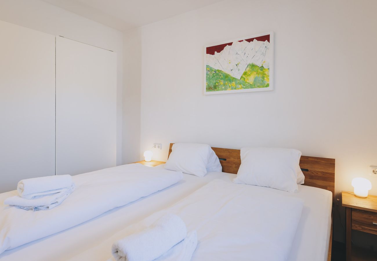 Schlafzimmer in der Ferienwohnung Haus Altenberger Apartments by we rent. Gemütliuches Doppelbett mit Bettwäsche.